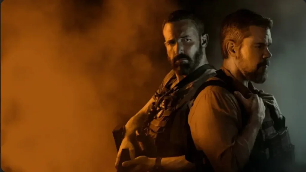 Ben Affleck and Matt Damon wearing tactical vests stand back-to-back in a smoky, dramatic scene lit.