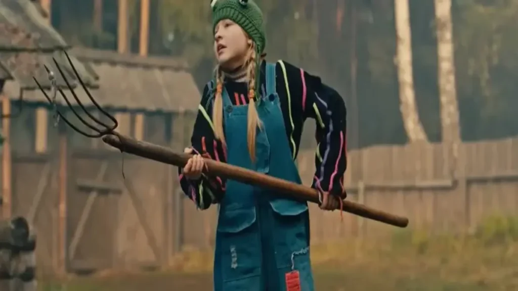 Papa Bear (2026) Trailer: A Survival Story That Hits Close to Home Papa Bear 2026 trailer scene showing a young girl holding a pitchfork in a forest survival setting