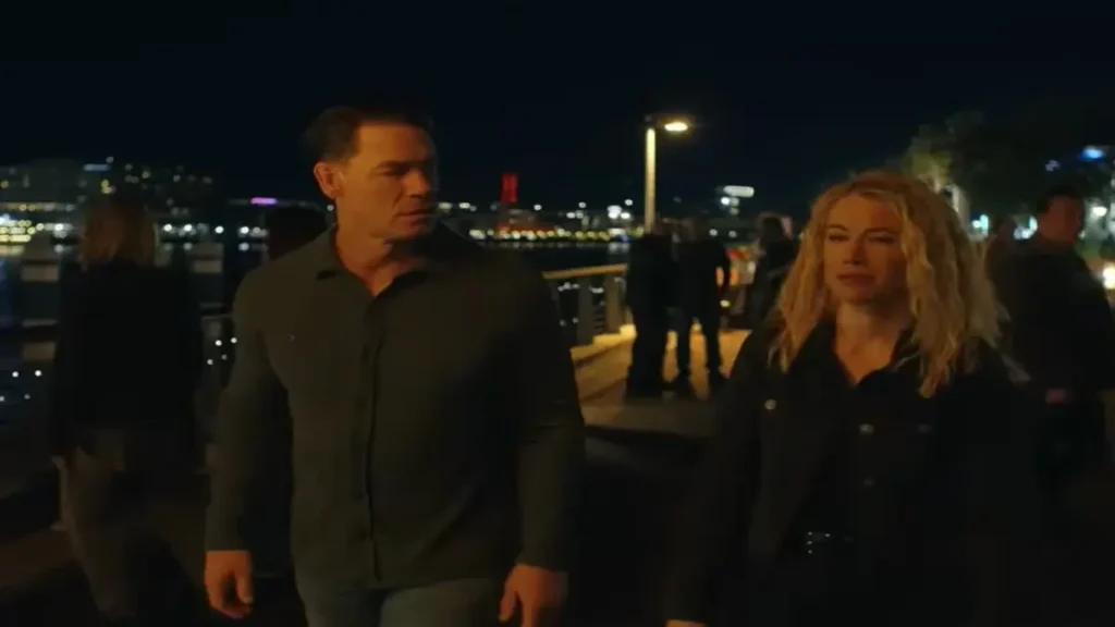 Why Peacemaker and Harcourt’s Relationship Feels So Real Two DC series characters walking side by side at night, sharing a tense but intimate moment on a city walkway.
