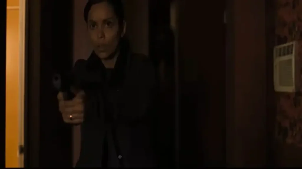 Woman holding a gun in a dim hallway scene from Psycho Killer 2026 thriller