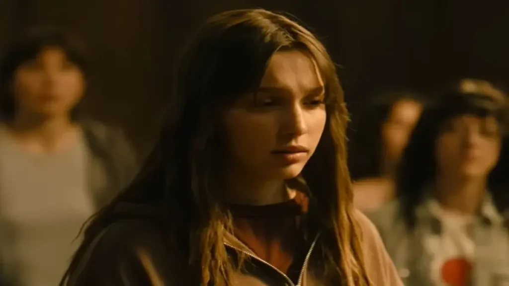 Woman standing in a classroom during an intense moment in the Feel My Voice Netflix trailer.