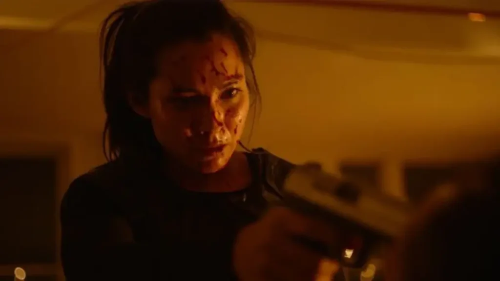 Bloodied female character aiming gun in intense infiltrate trailer scene