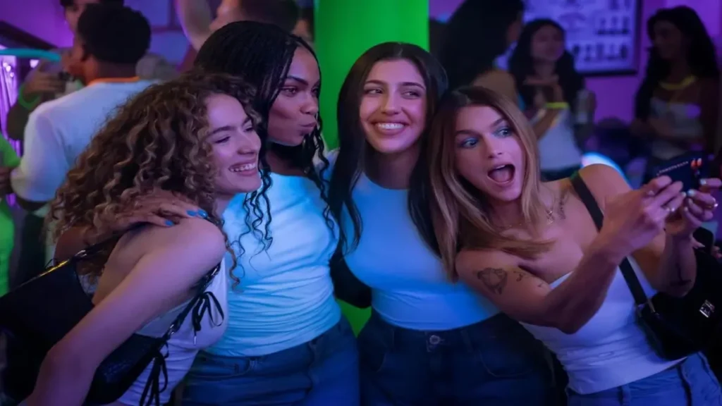 Four friends taking a selfie during a party scene from the Roommates Netflix trailer.