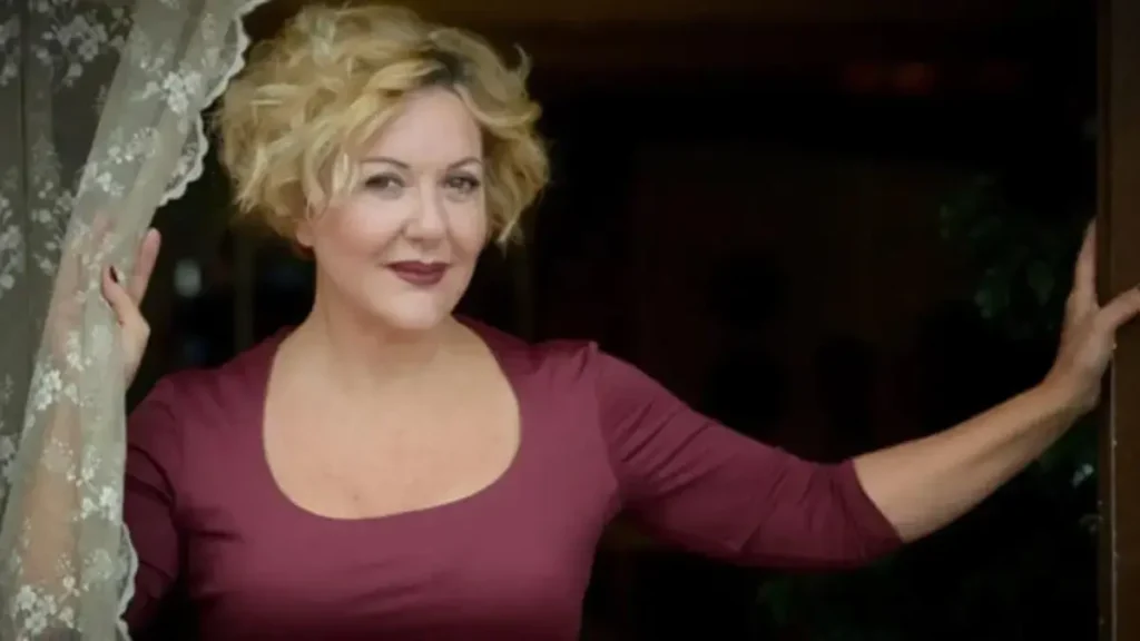 Lead actress from psychological thriller Selma standing at a window during filming scene