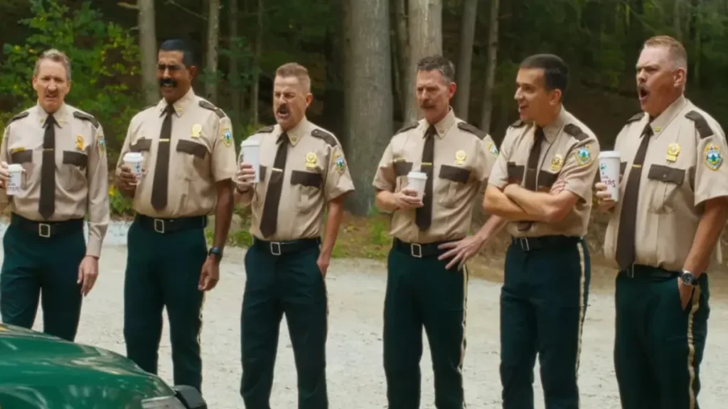 Super Troopers 3 cast standing in uniform during comedic roadside scene