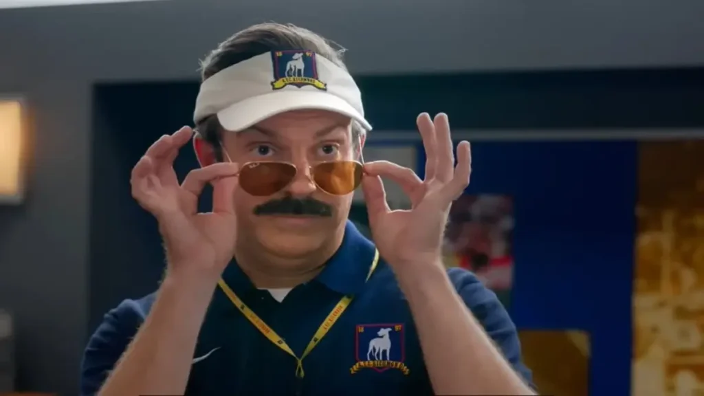 Ted Lasso coach adjusting sunglasses in Season 4 teaser scene