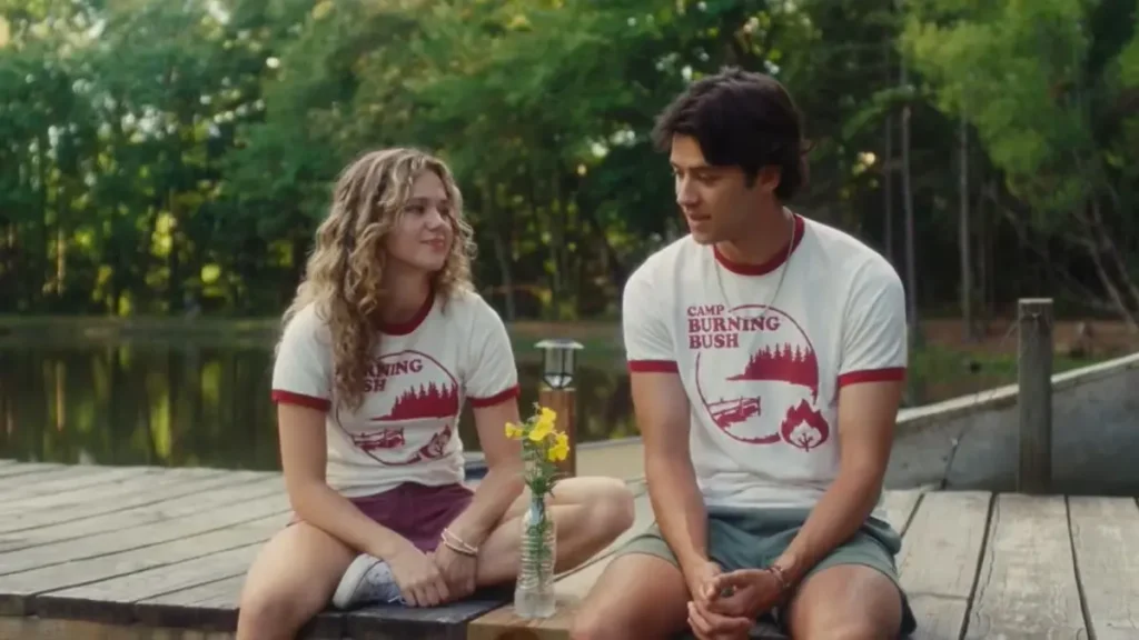 Bad Counselors movie trailer scene featuring two camp counselors sitting by a lakeside dock at summer camp