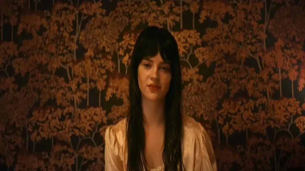 Woman standing against dark floral wallpaper in Her Private Hell official teaser scene