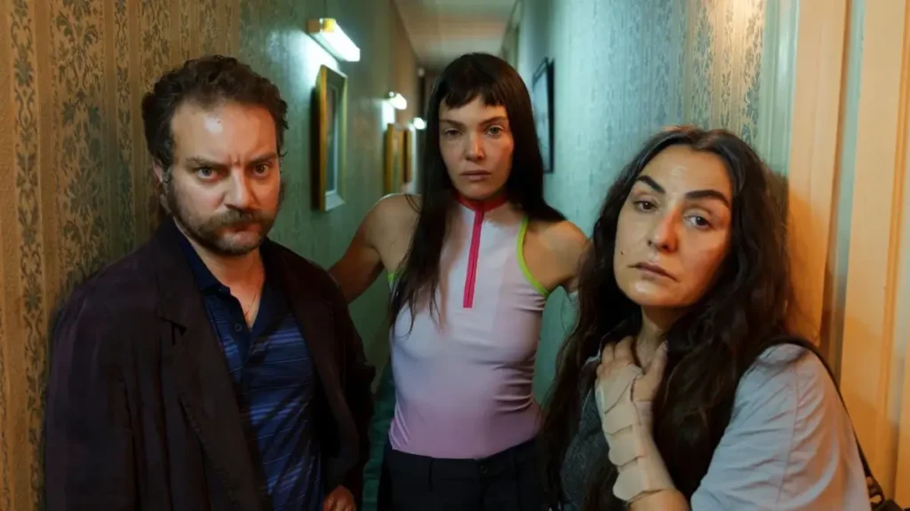 Cast members in Netflix thriller The Marked Woman standing in a dim hallway during an intense investigation scene.