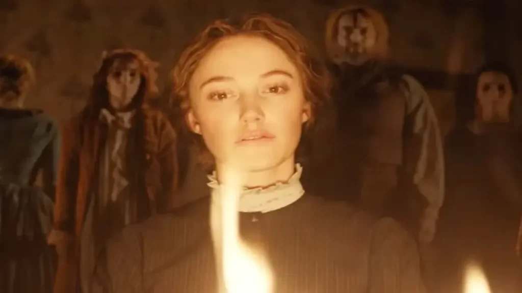 Woman holding candle in eerie Victorian mansion surrounded by masked figures in Victorian Psycho teaser.