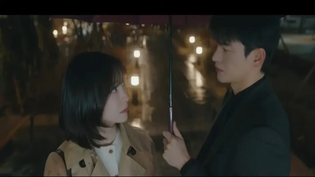 See You At Work Tomorrow official trailer scene featuring two coworkers sharing an emotional moment under an umbrella at night.